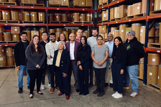 Chem-Impex team posing for a photo in a warehouse with shelves and boxes in the background.